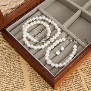 Vue détaillée de l'ensemble de bijoux en perles avec bracelets et clous dans un coffret