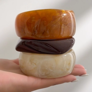 Three-piece chunky resin bangles set in amber, brown, and marble white finish