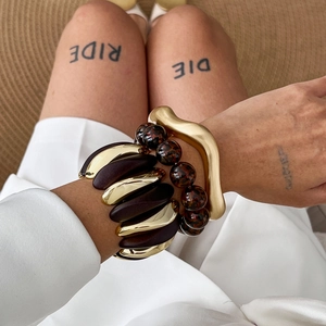Three-piece set of gold wave bangle, wooden stretch bracelet, and resin bead wristband