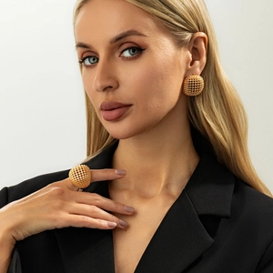 Detail of gold hollow grid sphere jewelry set including earrings and matching ring