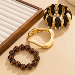 Three-piece jewelry set with gold metal cuffs and leopard print beaded bracelets