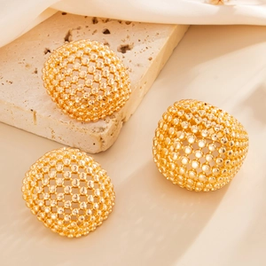Close-up of three gold hollow spherical rings with intricate metal bead mesh structure