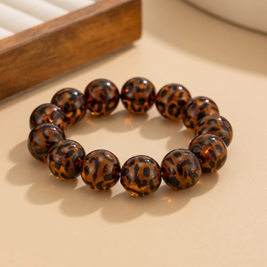 Close-up of leopard print amber beads on an elastic bracelet with warm brown tones