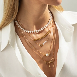 Multi-layer gold butterfly and baroque pearl necklace set shown on a model neck