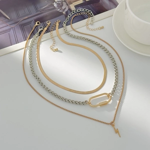 Three-piece layered necklace set with lightning pendant and flat snake chain on white desk