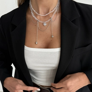 Détail du collier à perles multicouches avec pendentifs cœur argentés sur modèle