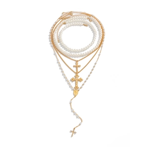 Layered gold cross pendant necklace with pearl chain and religious medallion details