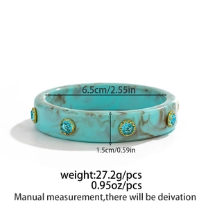 Detailed view of blue marble resin bangle with rhinestones and size measurements