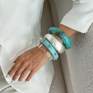 Chic 4-piece resin bangle set with marble texture and zircon stones on a female model
