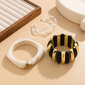 Detail showing irregular resin and chunky acrylic bangles with a matte block bracelet