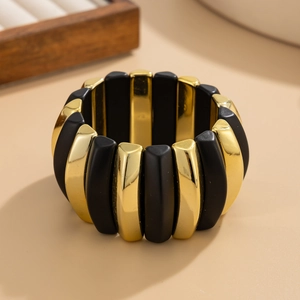 Macro shot of wide stretch bracelet with alternating matte black and gold plated beads