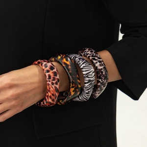 Set of four chunky resin bangles with leopard and animal prints on a model wrist