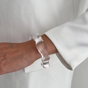 Gros plan sur un bracelet en résine acrylique transparente aux formes organiques modernes