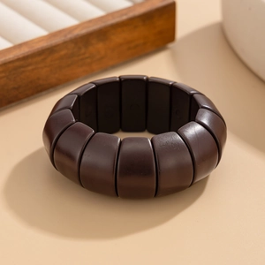 Détail d'un bracelet extensible en bois brun foncé poli au design segmenté et style naturel