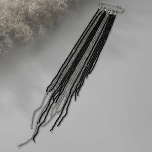 Macro shot of silver safety pin brooch with long crystal bead fringe tassels and metallic chains
