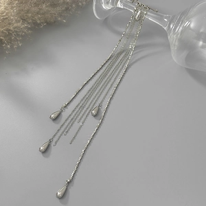 Détail de pompons à chaîne en métal argenté avec pendentifs goutte d'eau
