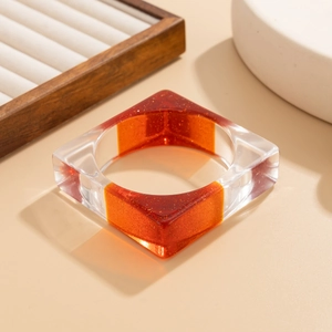 Vue détaillée du bracelet géométrique en résine avec paillettes orange et texture