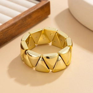 Détail d'un bracelet géométrique irrégulier plaqué or avec des modules métalliques triangles