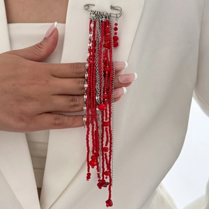 Broche à pompon en perles rouges et épingle argentée sur revers de costume blanc chic