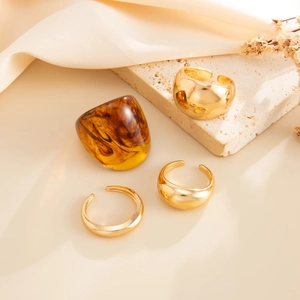 Detail of amber resin marble ring and adjustable gold dome rings on silk and stone