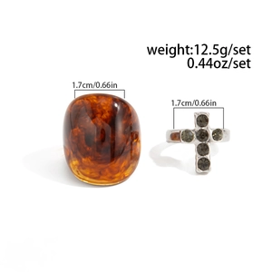 Detail view of resin amber ring and silver cross ring set with size and weight specs