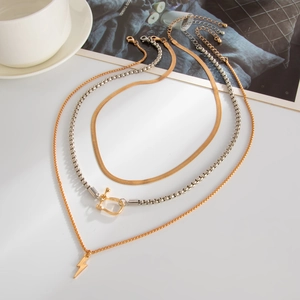 Close-up of layered gold necklaces with snake chain and lightning bolt pendant details