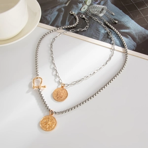 Detail of layered gold and silver mixed chains with coin pendants and lobster clasp