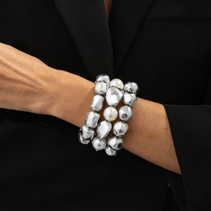 Detail of multi-layer elastic bracelet with silver textured beads and pearls on wrist
