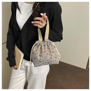 Detail of grey corduroy mini bucket bag with heart bow prints and drawstring closure