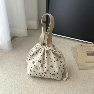 Detail of floral corduroy drawstring bag with heart patterns and canvas handles