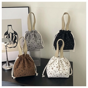 Detailed view of corduroy bucket bags with floral patterns and drawstring closure