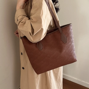 Brown textured large capacity tote bag with embossed pattern shown on woman shoulder