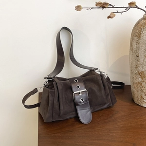 Vue détaillée d'un sac bandoulière en daim marron foncé avec sangle à boucle argentée