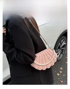Pink suede shell-shaped crossbody bag with elegant white pearl bead strap details