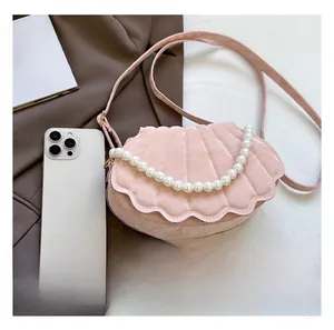 Pink shell-shaped crossbody bag with quilted texture and large faux pearl top handle detail