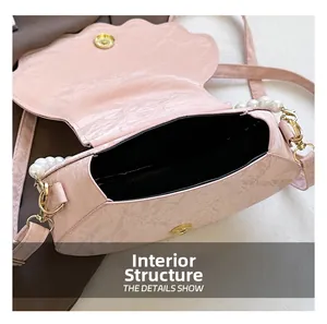 Pink shell shaped crossbody bag showing internal storage with golden magnetic buckle