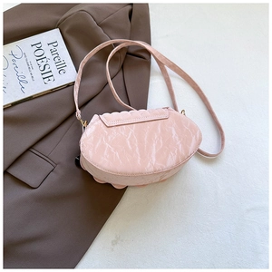 Pink crossbody bag featuring unique ruched texture on a stylish blazer background