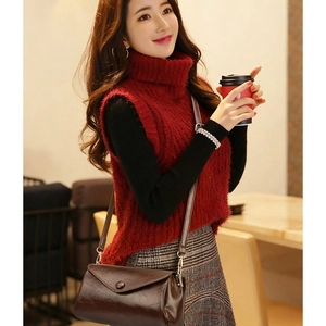 Minimalist brown oil wax leather crossbody bag worn by a model in a cozy cafe setting