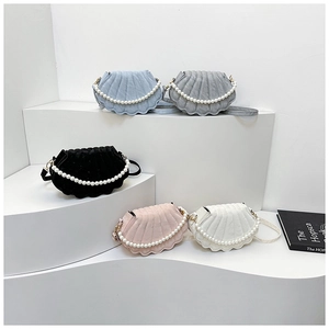 Detail of shell-shaped handbags with pearl handles and textured surface in various colors