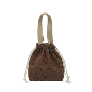 Brown corduroy drawstring tote bag with black heart and bow patterns in floral style