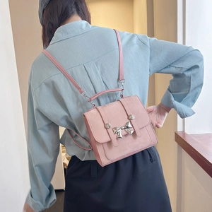 Vue détaillée du dos d'un mini sac à dos rose mat avec une boucle nœud en métal argent