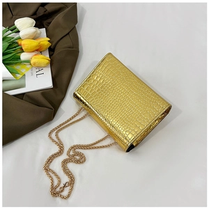 Macro shot of gold crocodile texture small bag with elegant metal chain strap detail