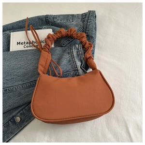 Borsa a mezzaluna marrone con manico a nuvola increspata su giacca di jeans
