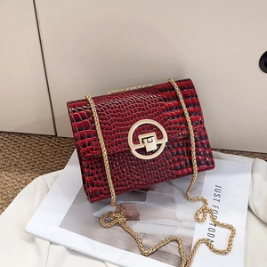 Detailed macro of dark red crocodile embossed leather texture with gold metal buckle