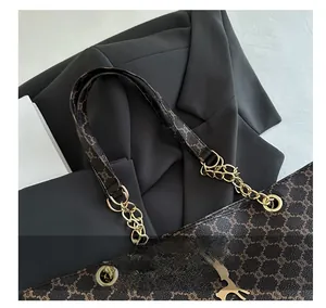 Détail du cabas marron à monogramme avec pendentif renne doré et bandoulière en chaîne