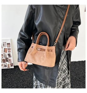 Lifestyle shot of khaki suede bucket bag with decorative buckle and slim crossbody strap