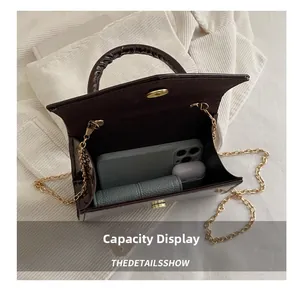 Detail view showing interior capacity of brown patent leather bag with gold chain strap