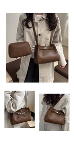 Detail of soft brown leather tote bag set with metallic buckle closure and matching pouch