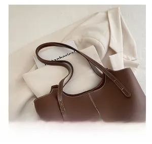 Vue détaillée du sac cabas en cuir marron avec surpiqûres blanches contrastées sur tissu