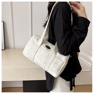 Close-up of white canvas Boston bag with grey star prints and metal logo detail